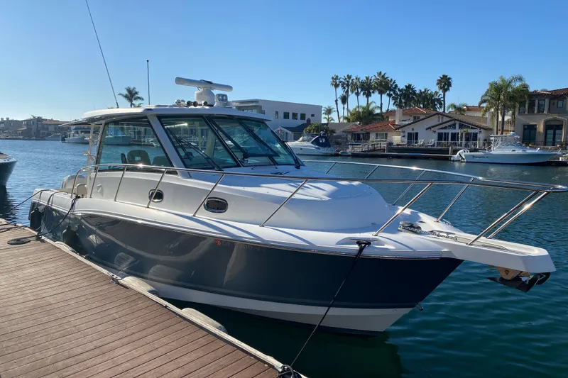 The Image of 2021 Boston Whaler 345 Conquest docked in a sunny marina setting. - 0