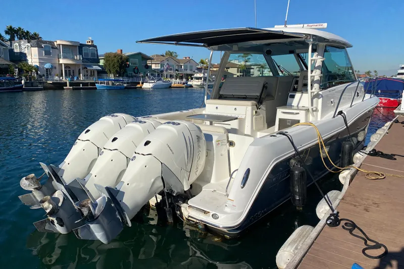 Slide: The Image of 2021 Boston Whaler 345 Conquest docked, featuring triple outboard engines. - 1