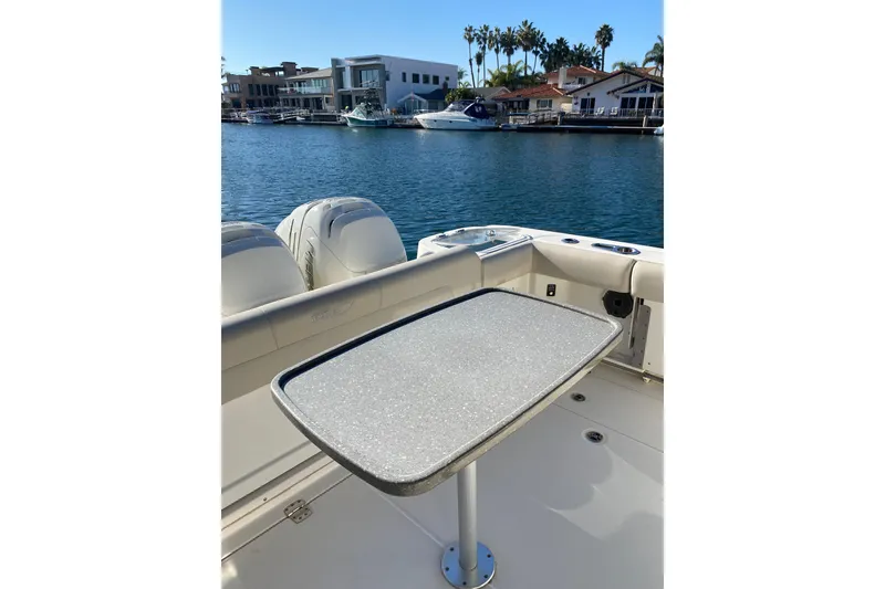 Slide: The Image of 2021 Boston Whaler 345 Conquest boat with table, docked in a scenic marina. - 16