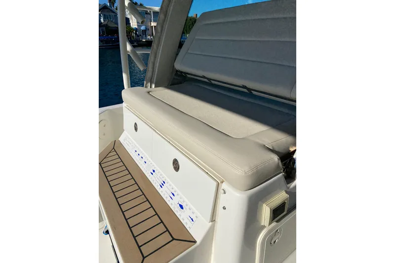 Slide: The Image of 2021 Boston Whaler 345 Conquest boat seating area with control panel and cushioned bench. - 19