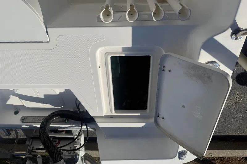 Slide: The Image of 2003 Sea Pro SV2100CC Bay Boat storage compartment with open hatch and rod holders. - 15