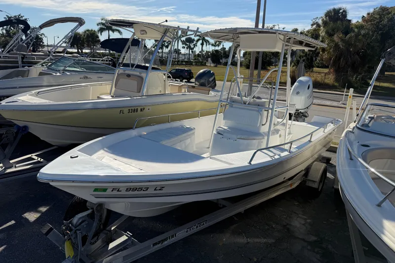Slide: The Image of 2003 Sea Pro SV2100CC Bay Boat on trailer, parked among other boats. - 2