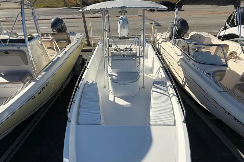 Slide: The Image of 2003 Sea Pro SV2100CC Bay Boat with T-top, docked between two other boats. - 34