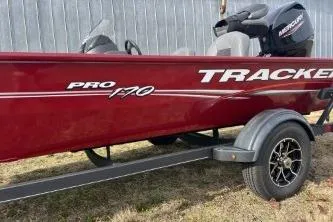 The Image of 2023 Tracker Pro 170 boat on trailer, red exterior, Mercury engine, parked outdoors. - 1