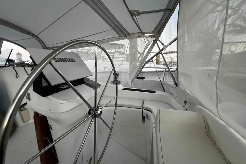 Slide: The Image of Interior view of 2007 Beneteau 393 sailboat cockpit with steering wheel and Simrad equipment. - 2
