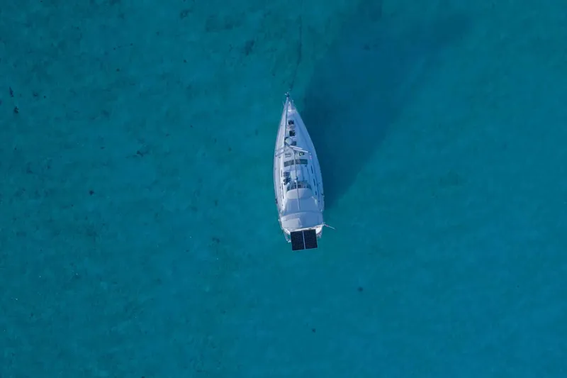 Slide: The Image of 2007 Beneteau 393 sailboat docked at marina, featuring covered cockpit and clear skies. - 33