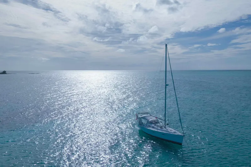 Slide: The Image of 2007 Beneteau 393 sailboat anchored in clear blue waters under a sunny sky. - 35