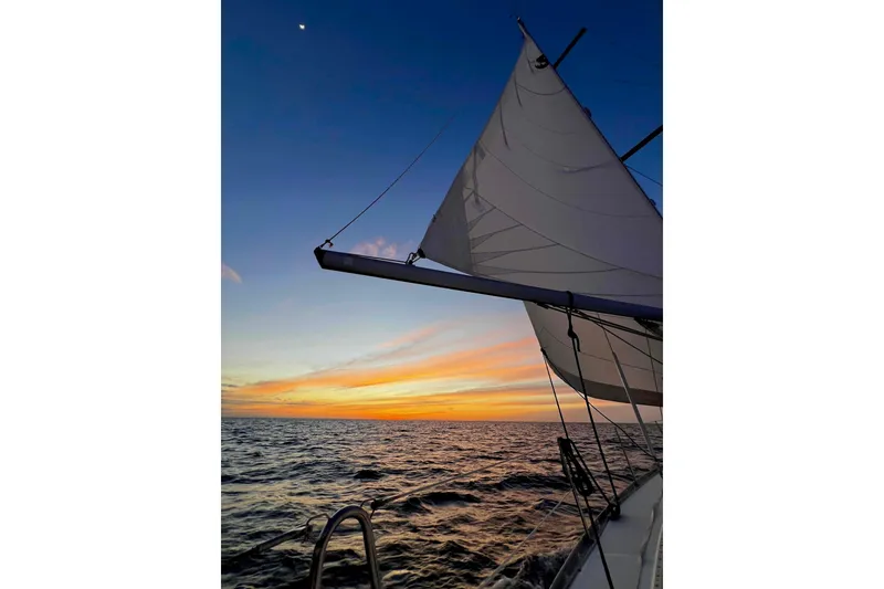 Slide: The Image of 2007 Beneteau 393 sailboat anchored in serene blue waters near lush islands. - 39