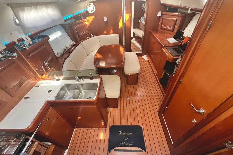 Slide: The Image of Interior of 2007 Beneteau 393 yacht with wooden flooring and cozy seating area. - 4