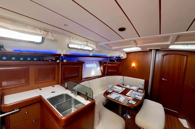 Slide: The Image of Interior of 2007 Beneteau 393 yacht with wooden furnishings and cozy seating area. - 6