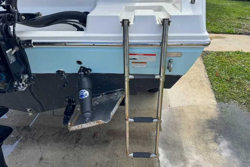 Slide: The Image of 2022 Cobia 220 Center Console boat with rear ladder and motor details. - 10