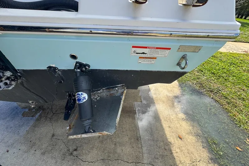 Slide: The Image of 2022 Cobia 220 Center Console boat stern with exhaust and warning labels. - 13