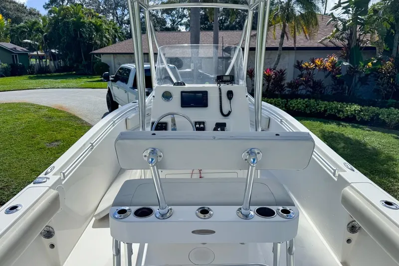 Slide: The Image of 2022 Cobia 220 Center Console boat with sleek design, parked in a lush garden setting. - 20