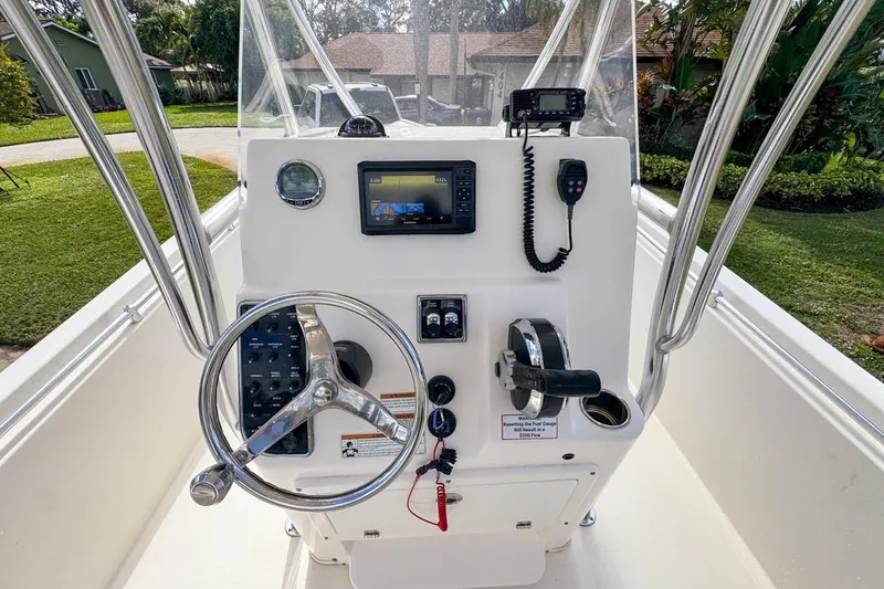 Slide: The Image of 2022 Cobia 220 Center Console boat dashboard with steering wheel and navigation equipment. - 29