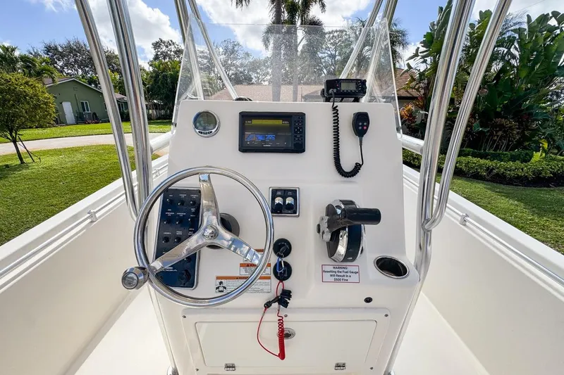 Slide: The Image of 2022 Cobia 220 Center Console boat dashboard with steering wheel and navigation controls. - 30