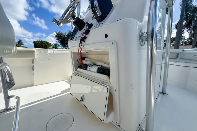 Slide: The Image of 2022 Cobia 220 Center Console boat interior with open storage compartment and steering wheel. - 33