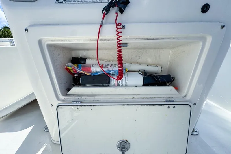 Slide: The Image of Storage compartment on a 2022 Cobia 220 Center Console boat with safety equipment. - 35