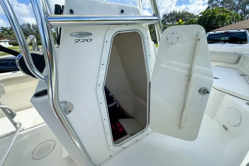 Slide: The Image of 2022 Cobia 220 Center Console boat with open storage compartment. - 38