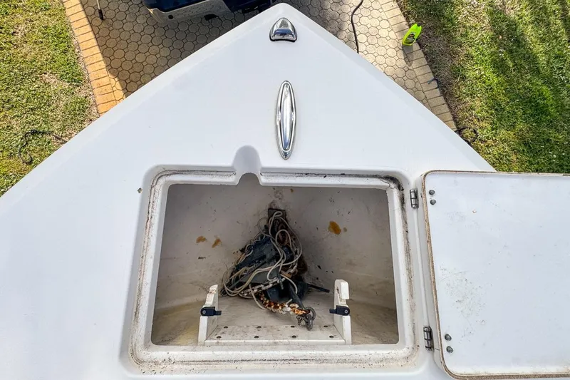 Slide: The Image of Open storage compartment on 2022 Cobia 220 Center Console boat, showing ropes inside. - 47