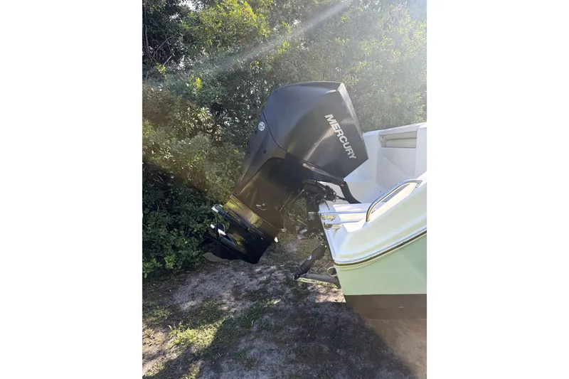 Slide: The Image of 2022 Cobia 220 Center Console boat on trailer, parked in a sunny residential area. - 6