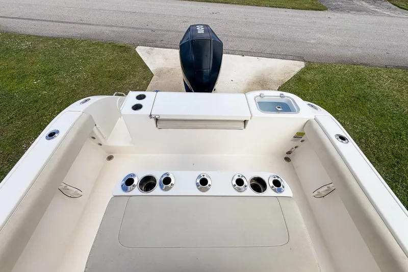 Slide: The Image of 2022 Cobia 220 Center Console boat with rod holders and outboard motor. - 66