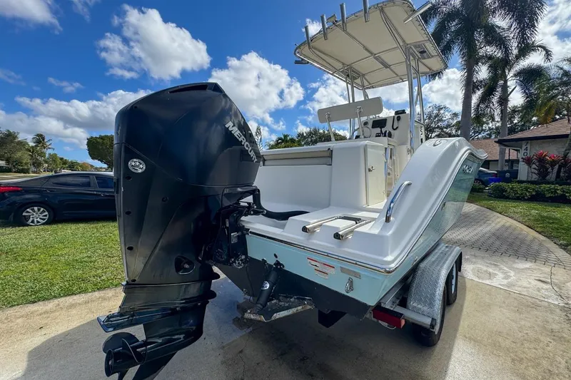 Slide: The Image of 2022 Cobia 220 Center Console boat with Mercury outboard engine on trailer, parked outdoors. - 7