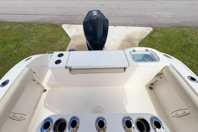 Slide: The Image of 2022 Cobia 220 Center Console boat interior with motor and fishing rod holders. - 72