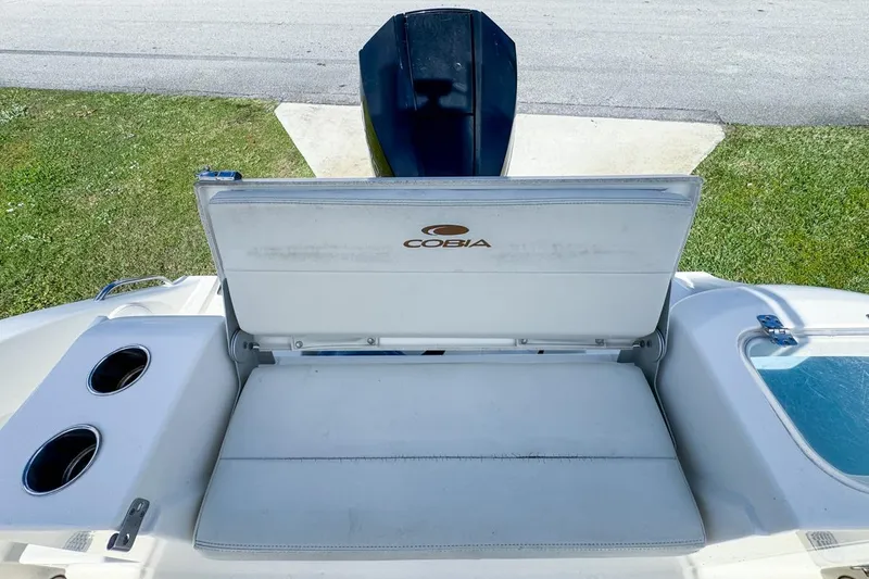 Slide: The Image of 2022 Cobia 220 Center Console boat with open storage compartment and cup holders. - 78
