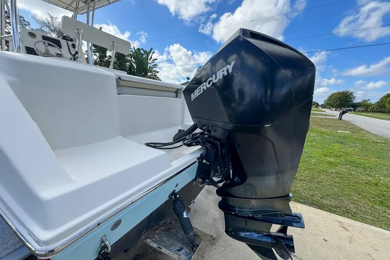 Slide: The Image of 2022 Cobia 220 Center Console boat with Mercury outboard motor, parked outdoors. - 8