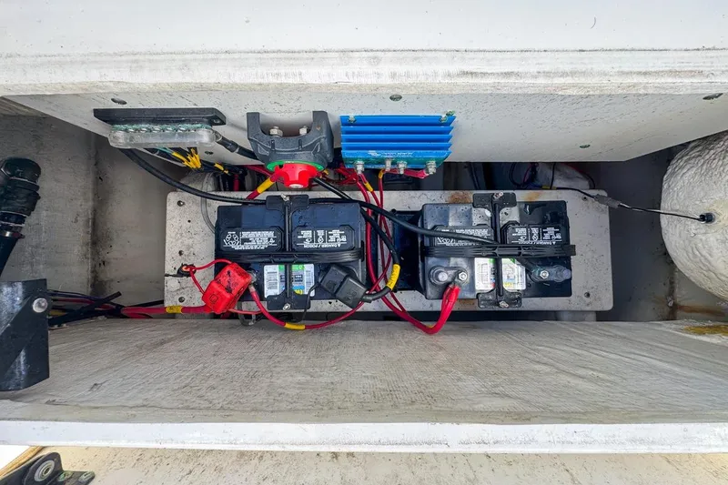 Slide: The Image of 2022 Cobia 220 Center Console boat battery compartment with wiring and components. - 80