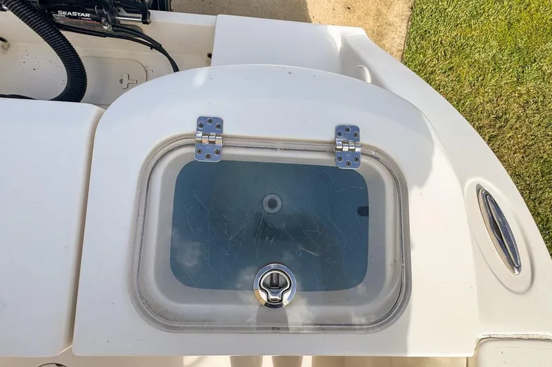 Slide: The Image of 2022 Cobia 220 Center Console boat livewell with transparent lid and latch. - 82