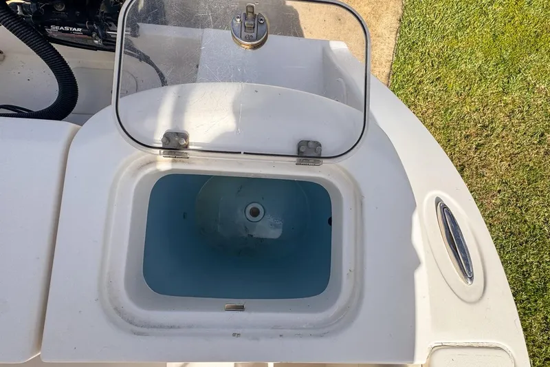 Slide: The Image of Open livewell on 2022 Cobia 220 Center Console boat, showing interior and lid. - 83