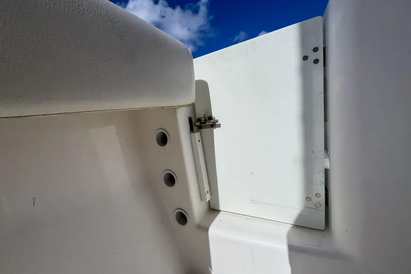 Slide: The Image of 2022 Cobia 220 Center Console boat interior detail with white panel and blue sky. - 85