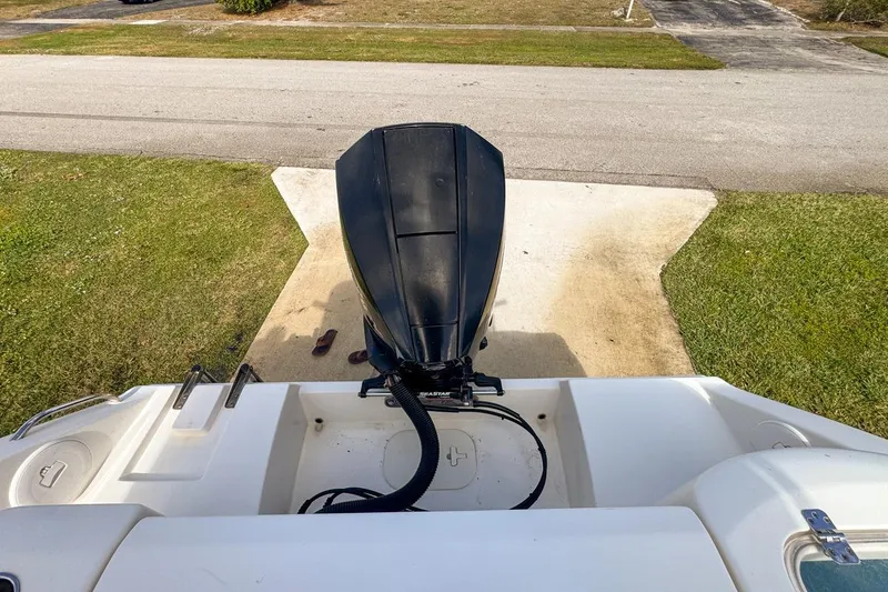 Slide: The Image of 2022 Cobia 220 Center Console boat with outboard motor on a driveway. - 90