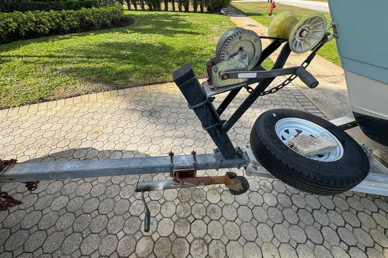 Slide: The Image of Trailer hitch and winch of 2022 Cobia 220 Center Console boat on paved driveway. - 91