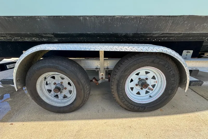 Slide: The Image of Trailer wheels for 2022 Cobia 220 Center Console boat on concrete surface. - 95
