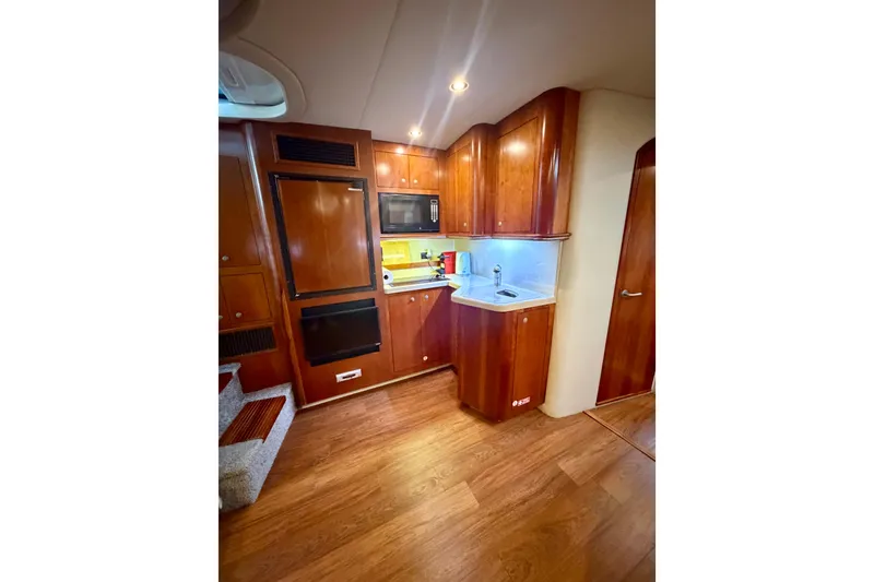 Slide: The Image of 2007 Cruisers Yachts 370 Express interior with wood cabinetry and modern kitchen amenities. - 10