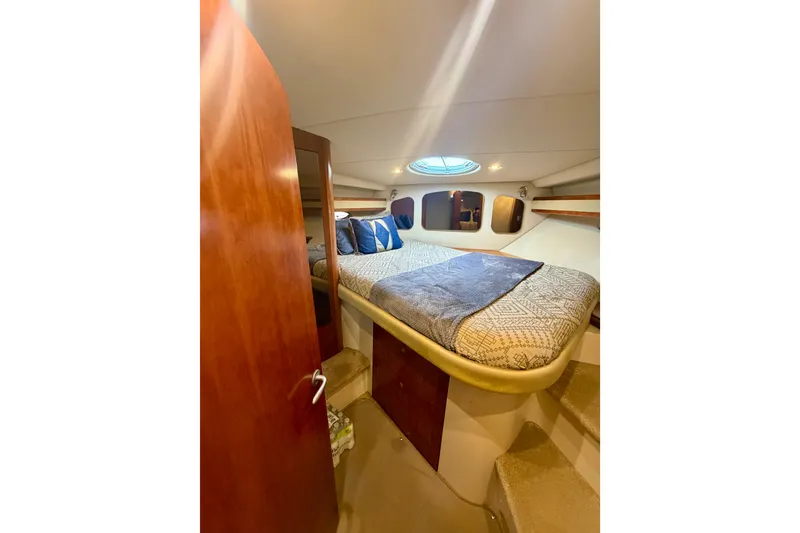 Slide: The Image of 2007 Cruisers Yachts 370 Express cabin interior with bed and wooden accents. - 14