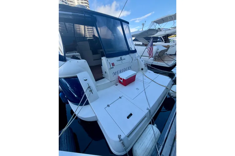 Slide: The Image of 2007 Cruisers Yachts 370 Express docked, featuring spacious deck and American flag. - 3