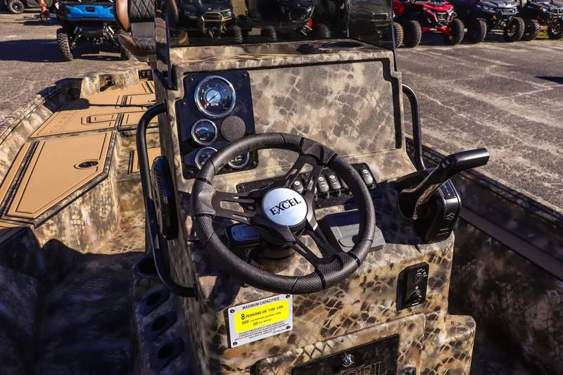 Slide: The Image of 2026 Excel 220 Bay Pro Elite boat dashboard with camo design and steering wheel. - 14