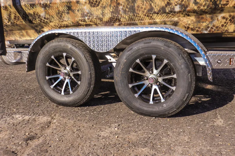 Slide: The Image of Trailer wheels of 2026 Excel 220 Bay Pro Elite boat on textured pavement. - 18