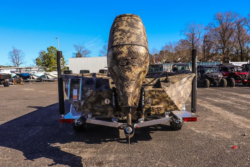 Slide: The Image of 2026 Excel 220 Bay Pro Elite boat with camouflage design, parked outdoors. - 3