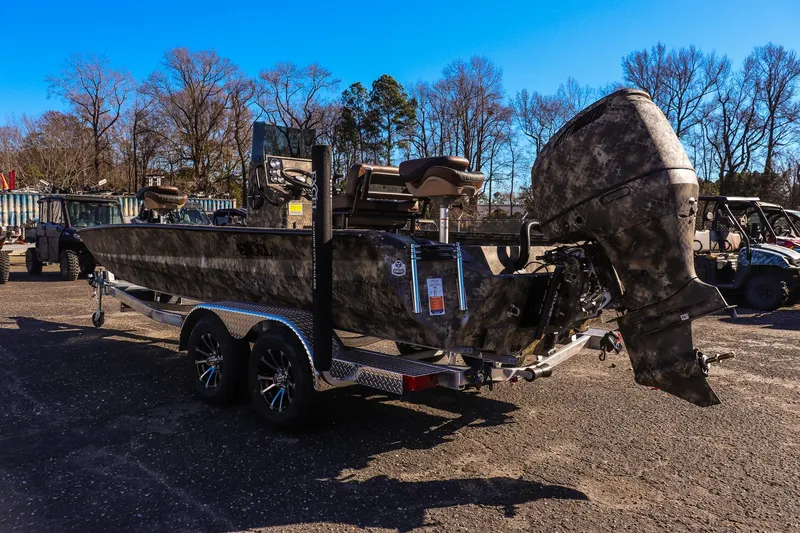 Slide: The Image of 2026 Excel 220 Bay Pro Elite boat with camouflage design on a trailer in a parking lot. - 4