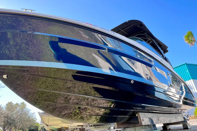 Slide: The Image of 2024 Sea Ray SLX 280 Outboard boat with sleek, shiny hull under clear blue sky. - 10