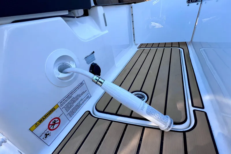 Slide: The Image of 2024 Sea Ray SLX 280 Outboard deck with hose and warning label. - 21