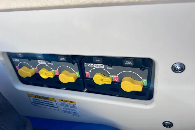 Slide: The Image of Control panel of 2024 Sea Ray SLX 280 Outboard with yellow switches and caution labels. - 22