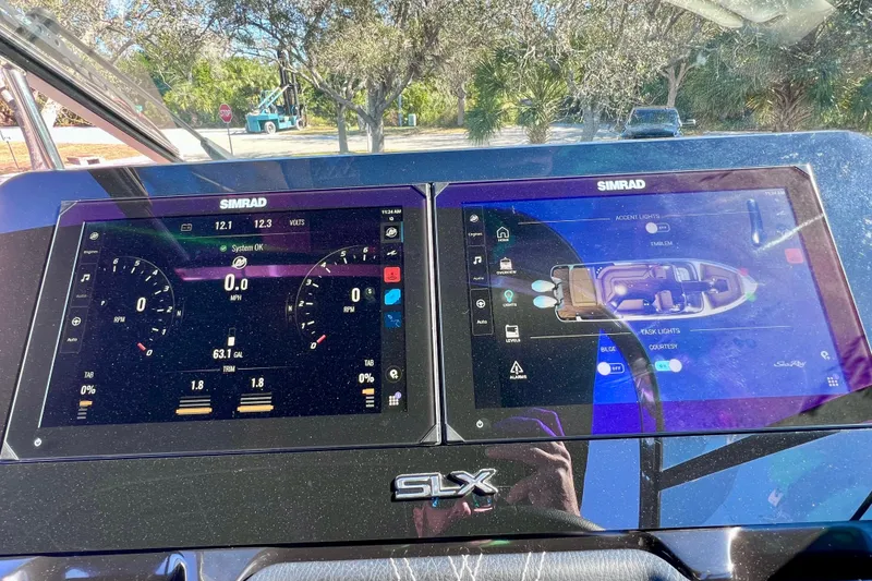 Slide: The Image of Dashboard of 2024 Sea Ray SLX 280 Outboard with Simrad displays showing controls and gauges. - 55