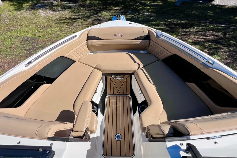 Slide: The Image of 2024 Sea Ray SLX 280 Outboard boat interior with tan seating and wood accents. - 65