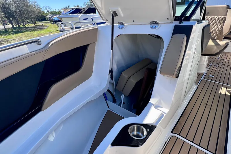 Slide: The Image of 2024 Sea Ray SLX 280 Outboard interior with open storage compartment and seating. - 71