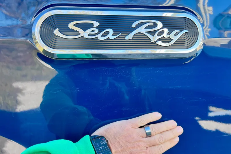 Slide: The Image of 2024 Sea Ray SLX 280 Outboard logo on blue surface with hand and smartwatch. - 81